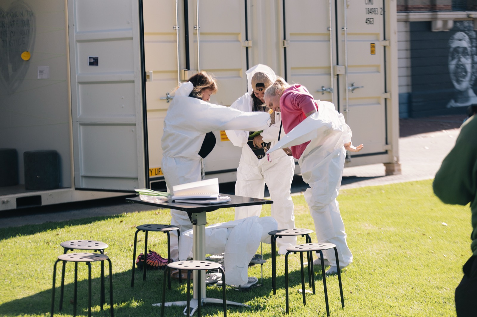 Visitors putting on white coveralls before entering CONTAINED in Adelaide
