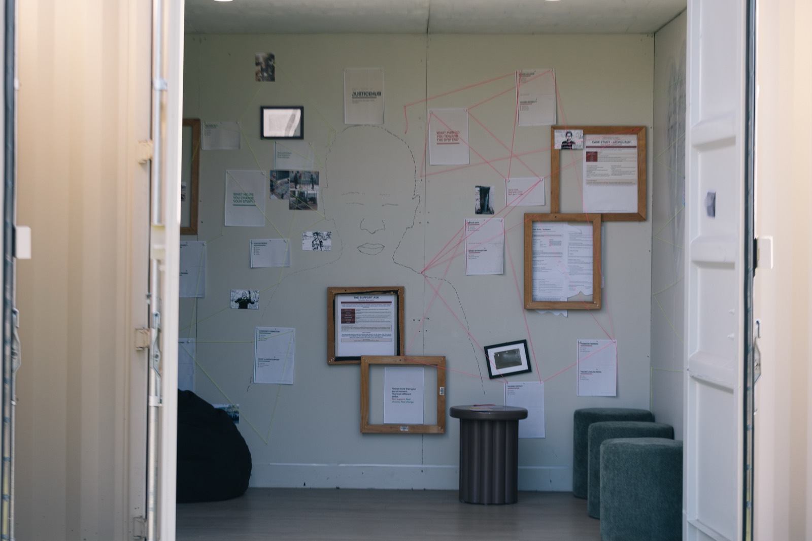 Interior wall of CONTAINED with case notes, images, string and reflection material