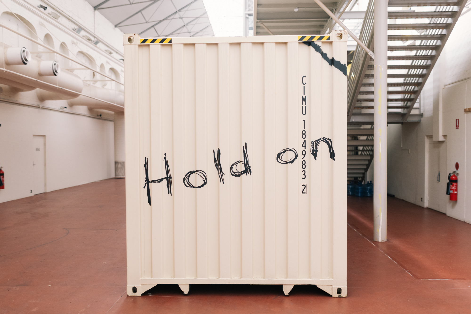 The end of the shipping container inside Tandanya, hand-painted with the words Hold on